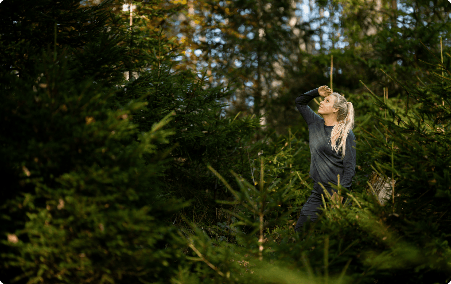 A woman looking up in the forest